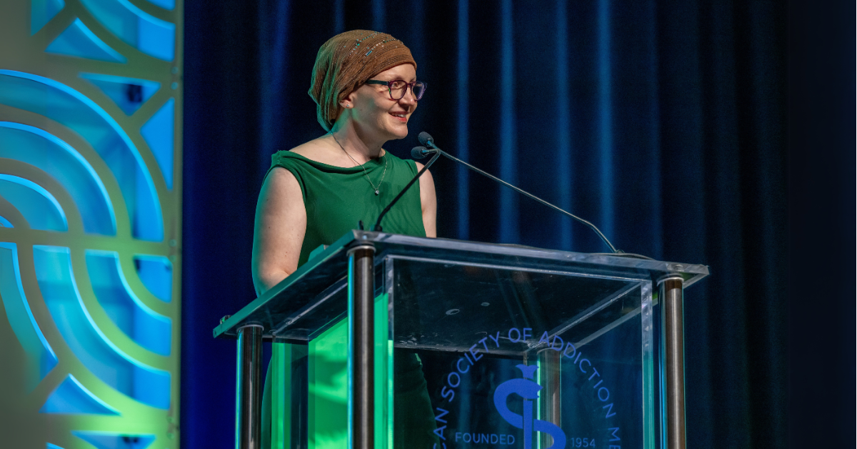 Cara Poland talking at a podium at the ASAM awards.